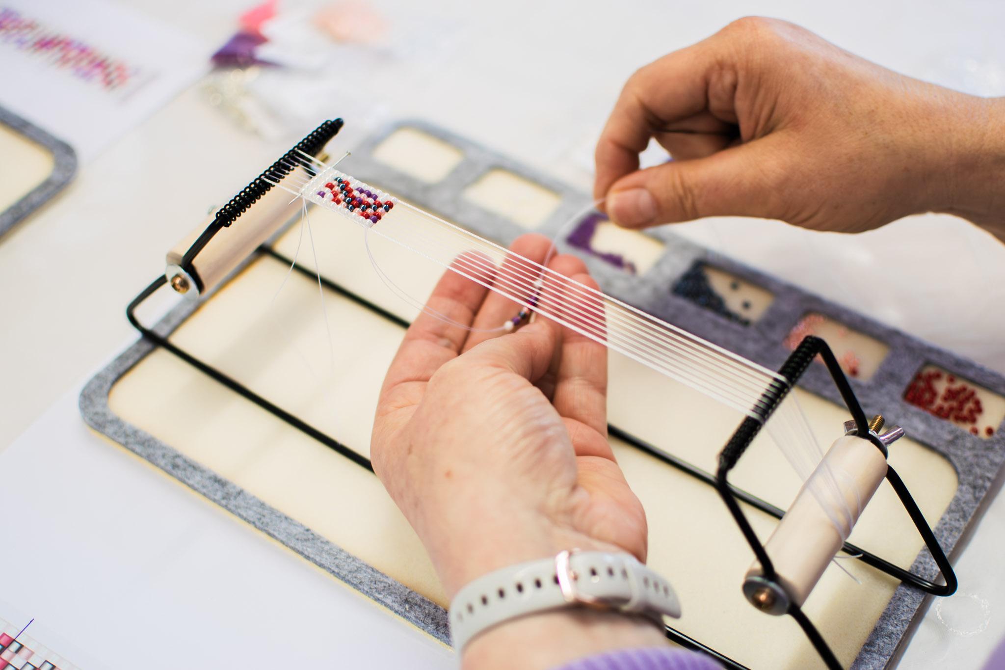 Kralenarmband maken op een weefraam - Foto